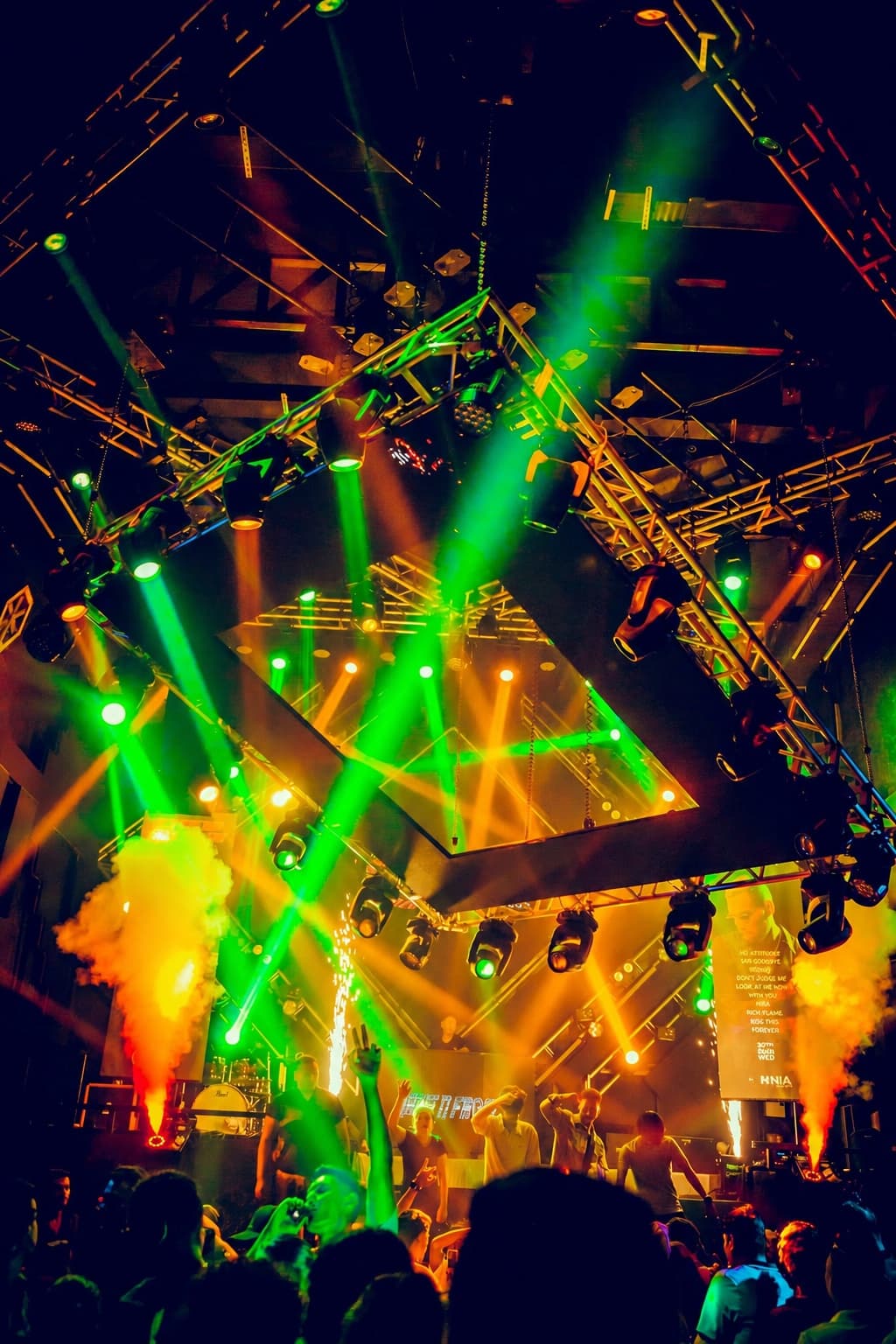 Green beams and CO2 jets over a live band on OMNIA's stage, the floor packed to the front