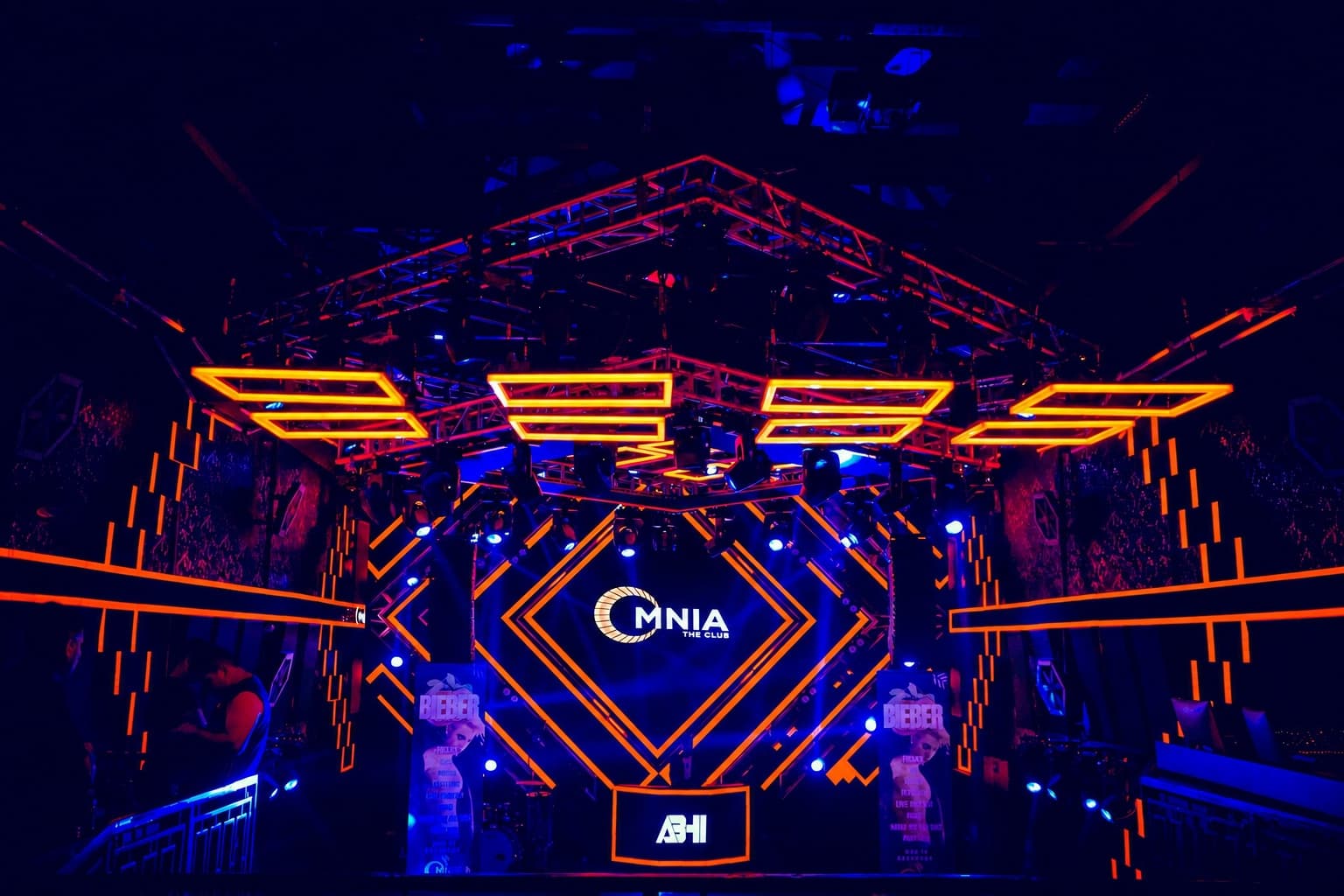 The OMNIA The Club logo lit on the main LED wall inside a frame of orange and blue neon